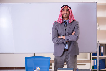 Young handsome arab teacher wearing suit 