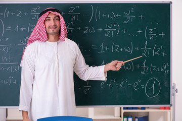 Arab teacher in front of chalkboard 