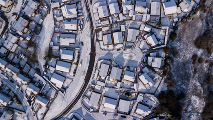 Aerial drone view of winding residential roads surrounded by fresh snowfall