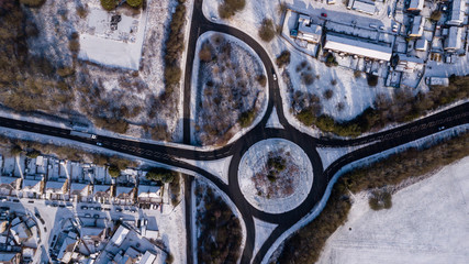 Aerial drone view of a traffic roundabout surrounded by fresh snowfall (Ebbw Vale, Wales, UK)