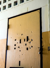 Broken holes on the old classroom door are locked