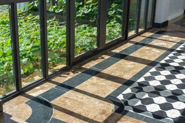 Green trees outside of glass wall view with vintage floor walk way