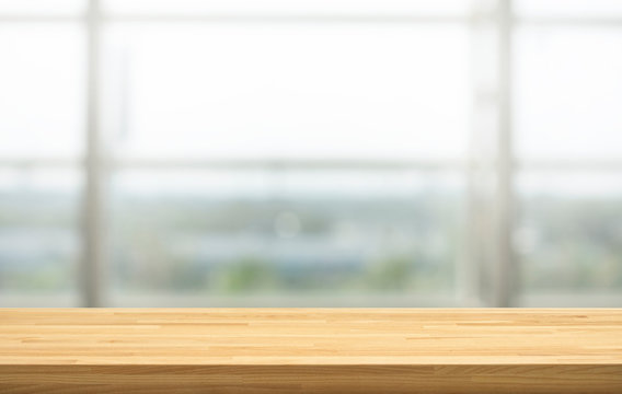 Wood table top on blur window glass, restaurant wall background.For montage product display or design key visual layout