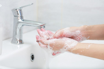 Washing hands with soap under the faucet with water. - 247105339