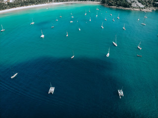 Aerial view of many anchoring yachts in open water. Ocean and sea travel and transportation..