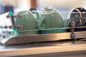 A stack of green  coffee cups lies on the rack in a row. close up