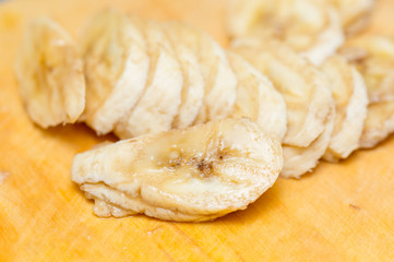 Banana slices on wooden board background