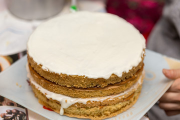 application of milk cream on the surface of the sweet cake