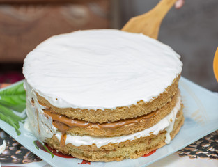 application of milk cream on the surface of the sweet cake