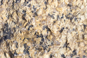 Stone surface of a dark yellow sandstone, background, texture