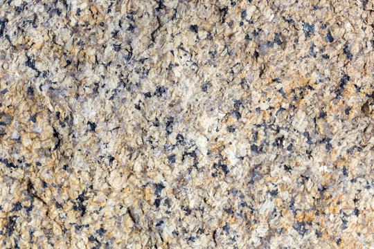 Stone surface of a dark yellow sandstone, background, texture