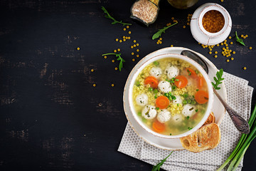 Italian meatball soup and  Stelline  pasta in bowl on black table. Dietary soup. Baby menu. Tasty...