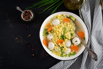 Italian meatball soup and  Stelline  gluten free pasta in bowl on black table. Dietary soup. Baby menu. Tasty food. Top view. Copy Space