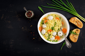 Italian meatball soup and  Stelline  gluten free pasta in bowl on black table. Dietary soup. Baby...