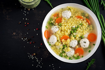 Italian meatball soup and  Stelline  gluten free pasta in bowl on black table. Dietary soup. Baby menu. Tasty food. Top view. Copy Space