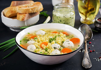 Italian meatball soup and  Stelline  gluten free pasta in bowl on black table. Dietary soup. Baby menu. Tasty food.