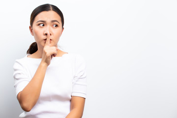 Woman making hush gesture standing isolated over white background