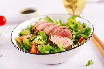 Tuna salad. Japanese traditional salad with pieces of medium-rare grilled Ahi tuna and sesame with fresh vegetable on a bowl. Authentic Japanese food.