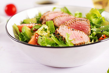 Tuna salad. Japanese traditional salad with pieces of medium-rare grilled Ahi tuna and sesame with fresh vegetable on a bowl. Authentic Japanese food.
