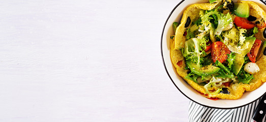 Omelet with fresh tomatoes, black olive, avocado and mozzarella cheese. Omelette salad. Breakfast. Healthy food. Top view. Banner. Flat lay