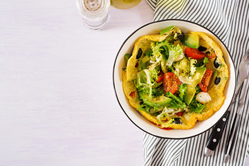 Omelet with fresh tomatoes, black olive, avocado and mozzarella cheese. Omelette salad. Breakfast. Healthy food. Top view. Flat lay