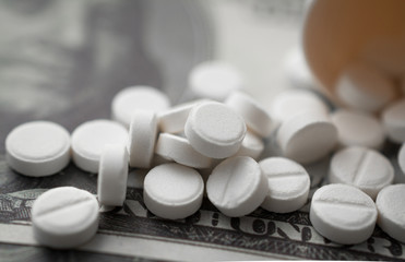 white round medicine tablets on money close-up shot