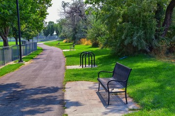 Views of Jordan River Trail with surrounding trees, Russian Olive, cottonwood and silt filled muddy water along the Wasatch Front Rocky Mountains, in Salt Lake City, Utah.