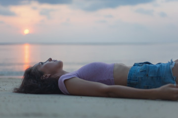 Young beautiful slim sensual woman lying on the sand on the beach, beauty and fashion, leisure and travel concept