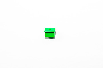 View from the top of the plastic miniature house in green as a part of the monopoly game on a white isolated background