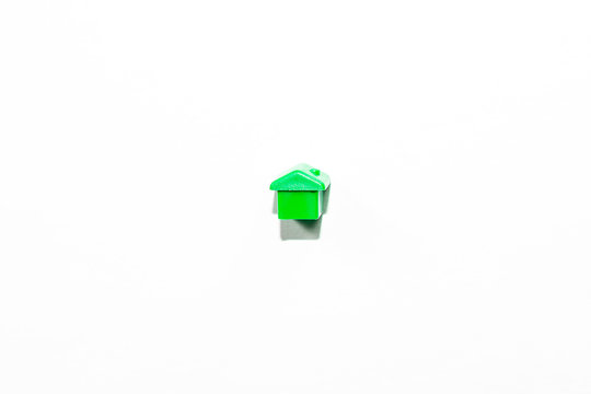 View From The Top Of The Plastic Miniature House In Green As A Part Of The Monopoly Game On A White Isolated Background