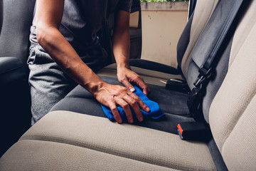 Worker man cleaning dust interior by cloth microfiber inside car