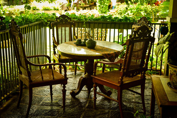 Traditional old vintage door to the historical houses with green color and open air garden and antique furniture