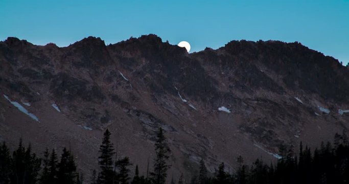 The moon sets over the Sawtooth Mountains, as seen from Imogene Lake. Time lapse.
