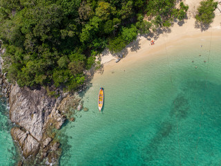 yellow boat  in beautiful turquoise ocean near  green island, top view, aerial photo.Tourists are sunbathing. Phuket. Thailand.