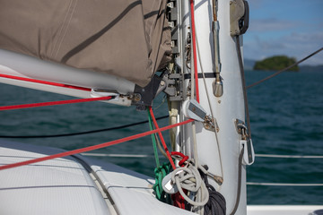 View of the blue sea water from the side of a sailboat with rigging and sails. Tackle barge, sail, masts, yards, deck, ropes, cables
