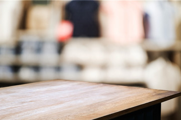 wood table in front of blur super market background.