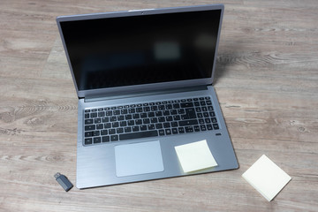 Draufsicht auf einen Laptop mit USB-Stick und Notizzettel