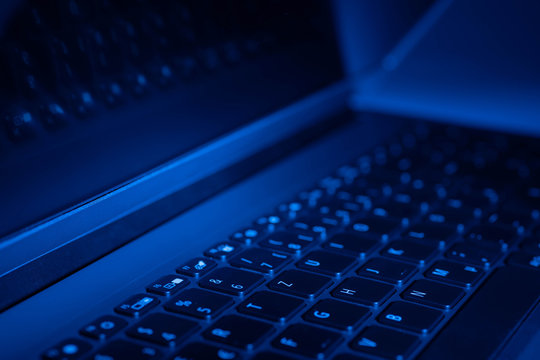 Ge&ouml;ffneter Laptop in blauem Licht