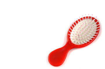 Elegant red hairbrush with handle isolated on white background.
