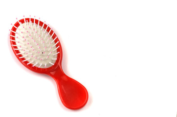 Elegant red hairbrush with handle isolated on white background.
