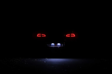 Led tail lights of modern car at night. Lights of licence plate