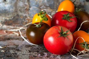 Mix from red, yellow and green tomatoes. Italian Cuisine. Dark background.