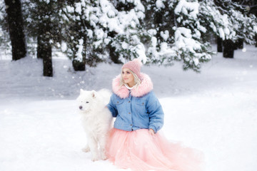 girl with a dog in the winter forest