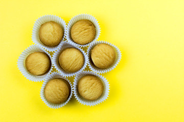 Cookies in paper baskets on yellow background