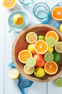 Sweet oranges, limes and lemons with on wooden table