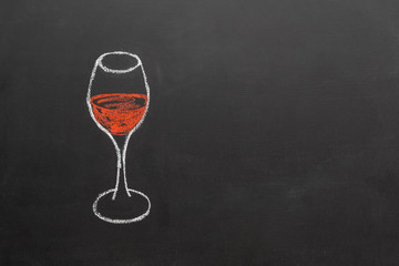 drawing of a glass of wine, made with chalk on a blackboard, with copy space