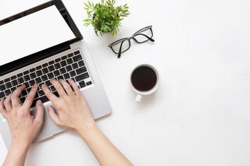 Man typing on laptop computer with white blank screen over white office desk table with cup of coffee. Top view with copy space, flat lay.