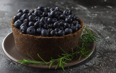 Blueberry vegan cheesecake. Dark photo on black background