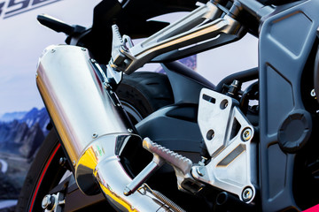 closeup motorcycle exhaust pipe with soft-focus and over light in the background