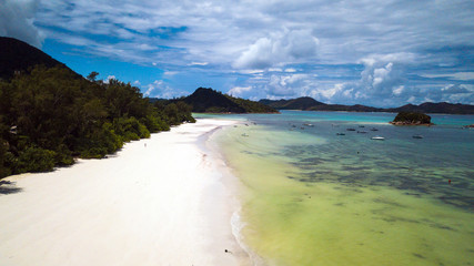 A view from above of the beautiful white beaches with a small island and blue lagoon